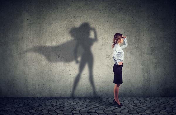 Protecting Your WordPress Website an image of a lady in office attire who's shadow is that of a hero wearing a cape