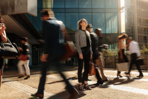 Professional woman standing still in a moving crowd, representing strategic focus and target market clarity.